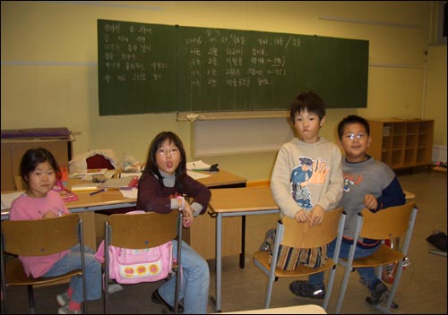 세종학교 초급반 : 수업중 칠판을 보며 함께 문장을 읽던 아이들이 기자가 사진을 찍자 뒤를 돌아보고 있다. 